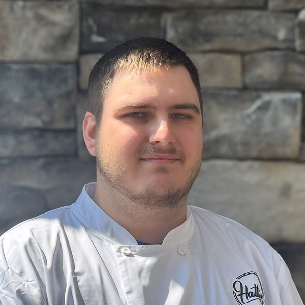 Chris Harding, Culinary Director at The Rushwood Senior Living, wearing a white chef coat with the 