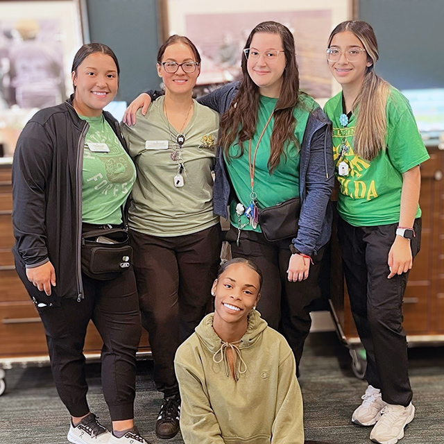 A group of team members smile at The Rushwood during an event.
