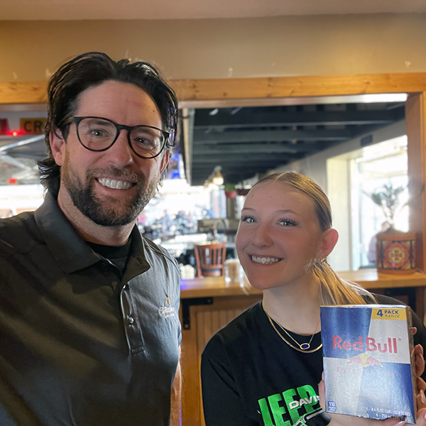 A team member from The Rushwood Senior Living smiles alongside a young woman at a local business.
